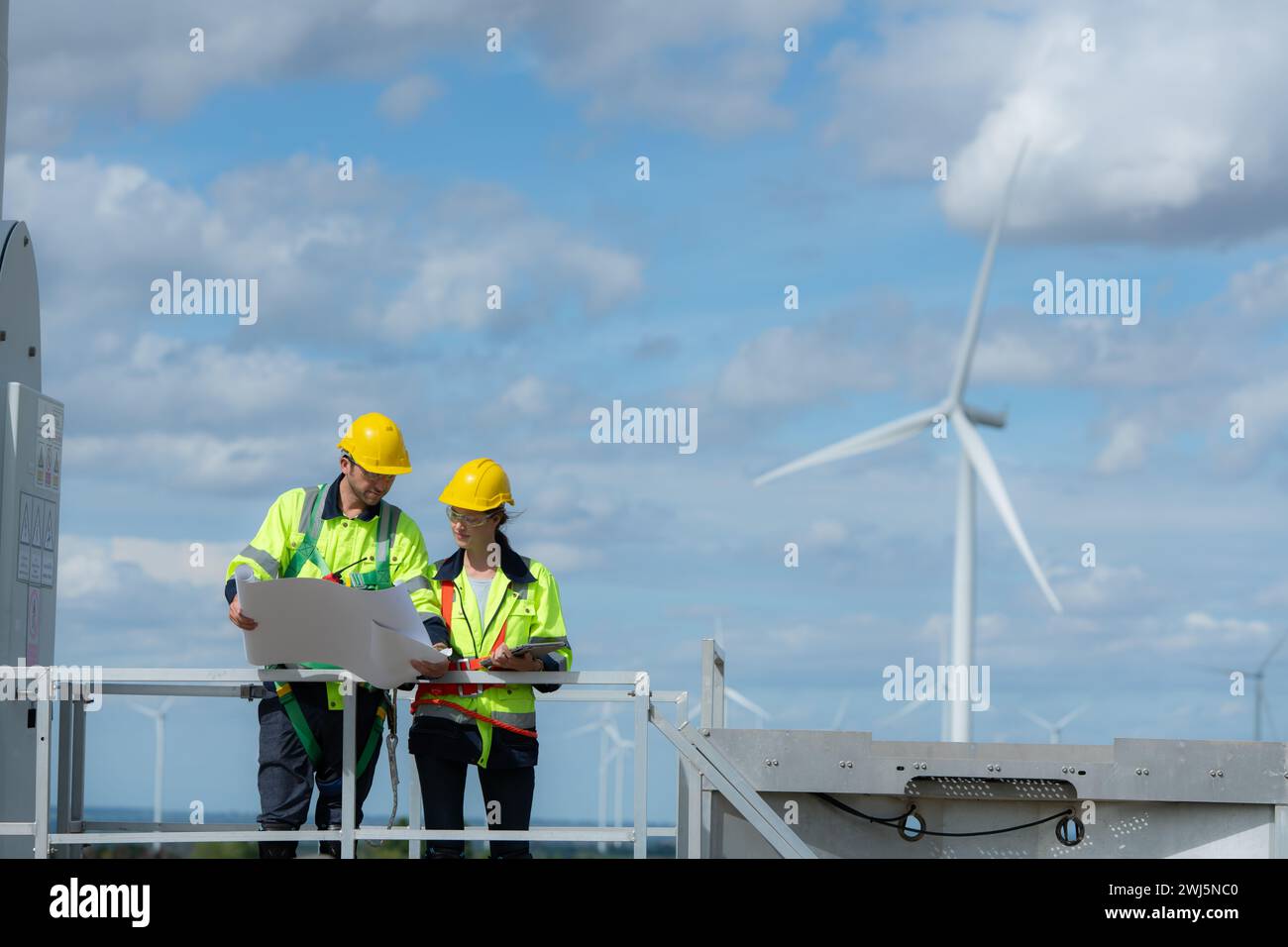 Ingenieur und Techniker besprechen ein Lösungsproblem der Windkraftanlage, bevor sie die Windkraftanlage überprüfen, das Konzept von natura Stockfoto