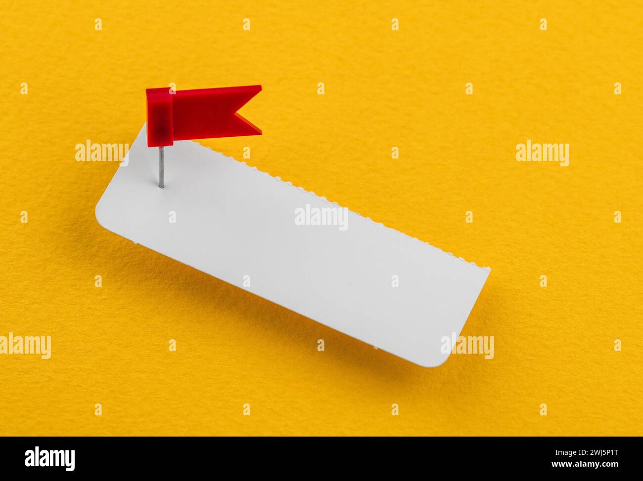Weißes Papier mit einem roten Druckstift in Form einer Flagge. Business-Branding Stockfoto