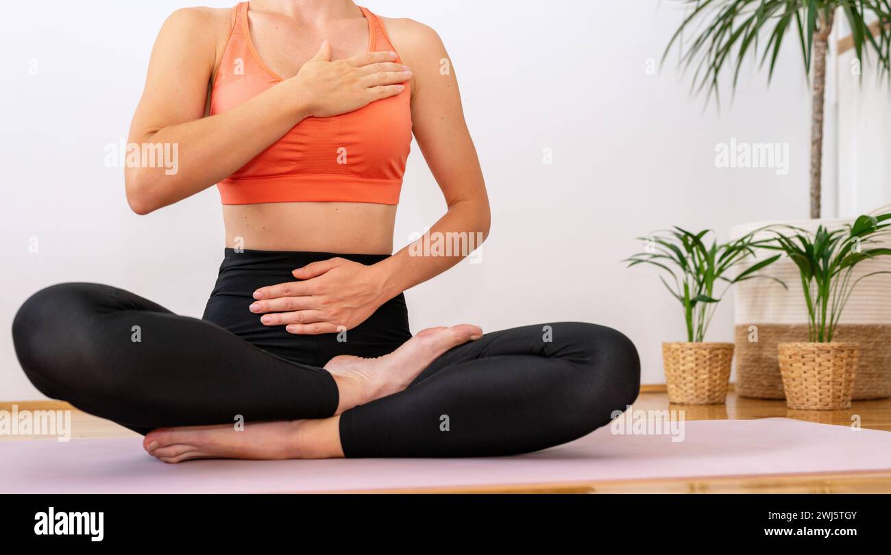 Atemübungen. Yoga-Meditationsübung. Frau in Yoga-Lotusposition auf der Trainingsmatte. Stockfoto
