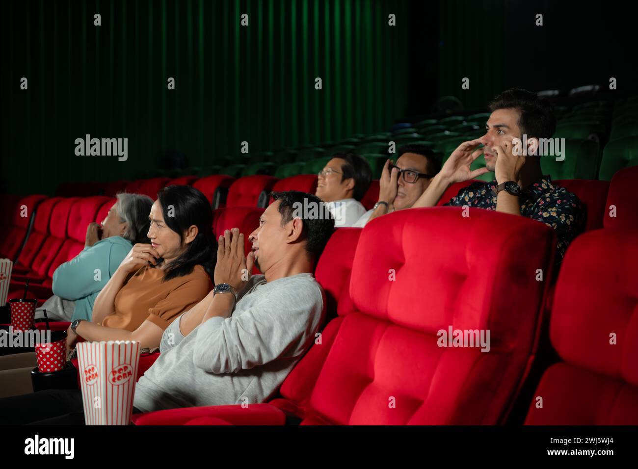 Wenn man in Kinos gruselige Geisterfilme ansieht, wirken die Kinobesucher verängstigt. Stockfoto