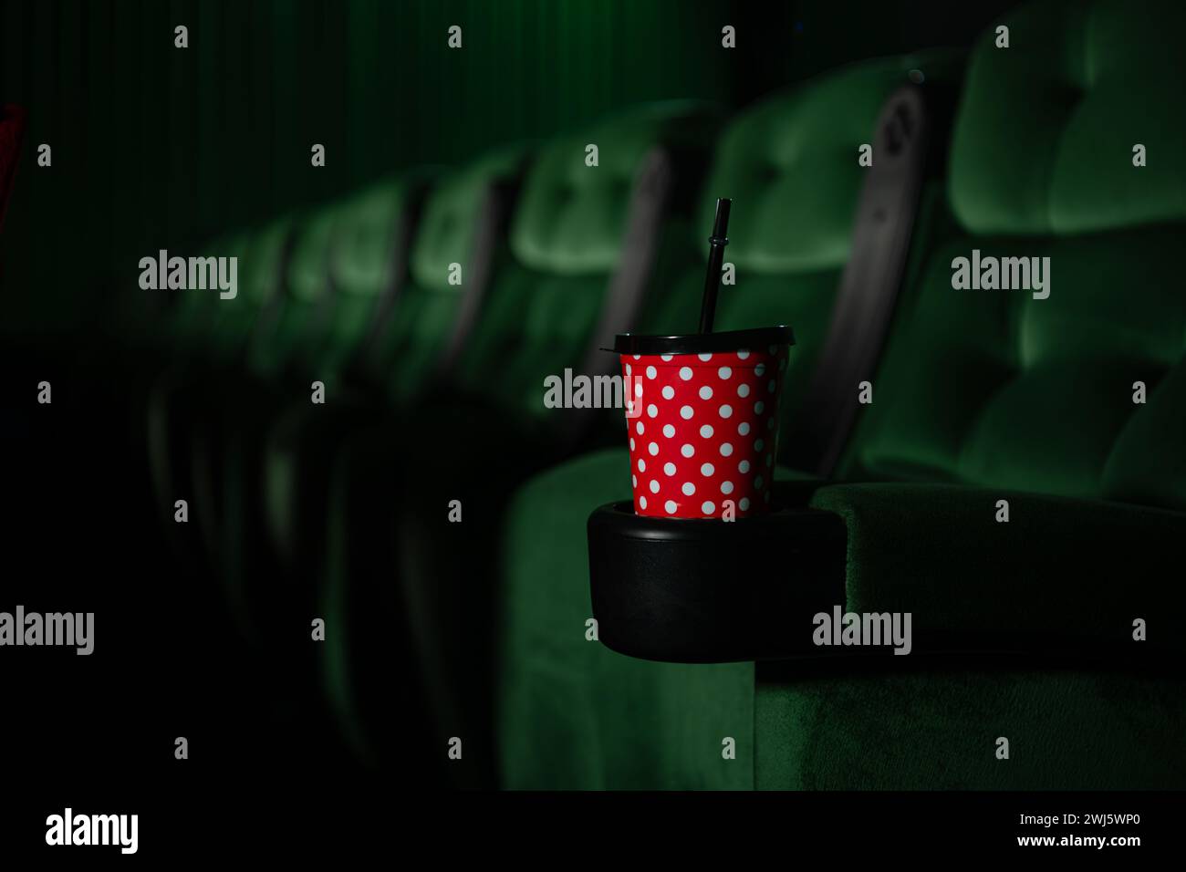 Kino-Auditorium mit grünen Sitzen und einem roten Getränk Stockfoto