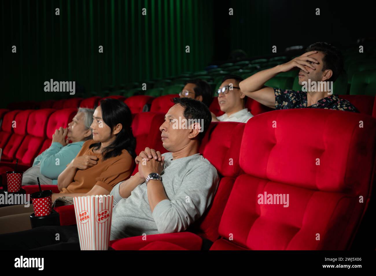 Wenn man in Kinos gruselige Geisterfilme ansieht, wirken die Kinobesucher verängstigt. Stockfoto