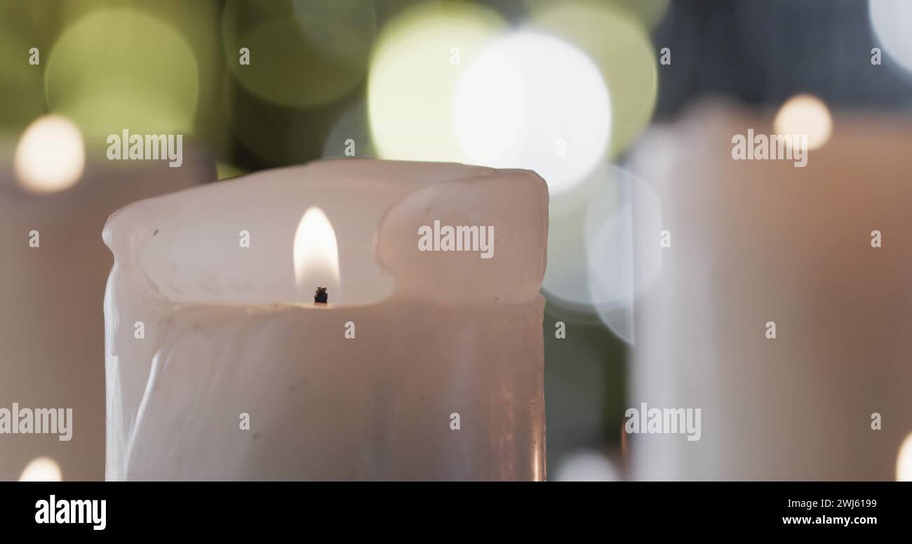 Bild des Begrüßungstextes der Jahreszeiten über beleuchtetem Kerzenhintergrund Stockfoto