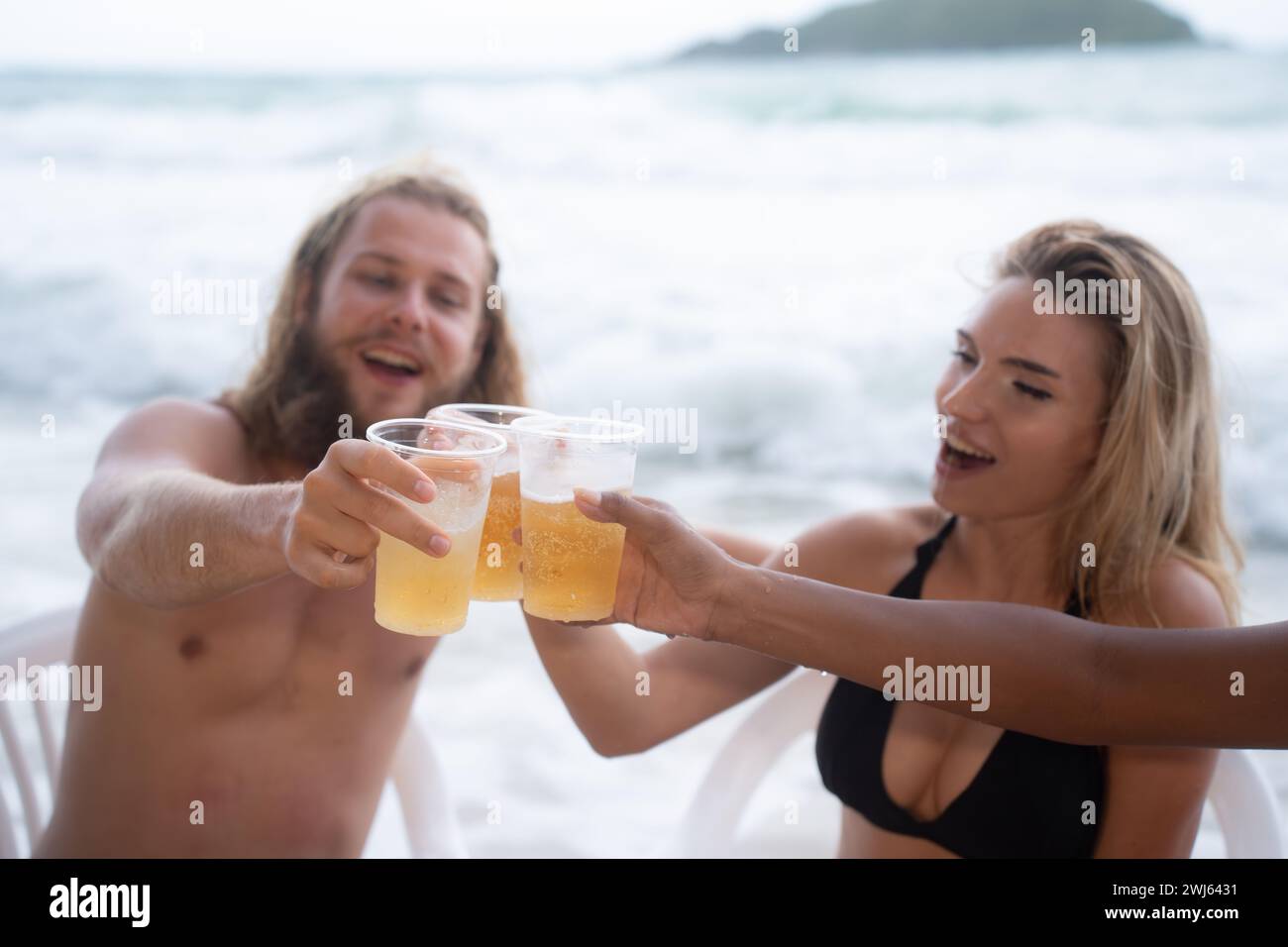 Multi-ethnische Gruppe von Freunden, die Spaß am Strand haben, Bier trinken und Spaß haben Stockfoto