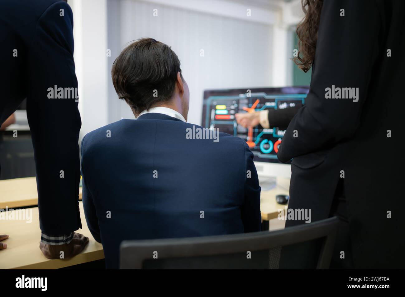 Ein breites Team von Geschäftsleuten und Ingenieuren berät bei der Entwicklung einer Windkraftanlage, die Windenergie in Elektri umwandelt Stockfoto