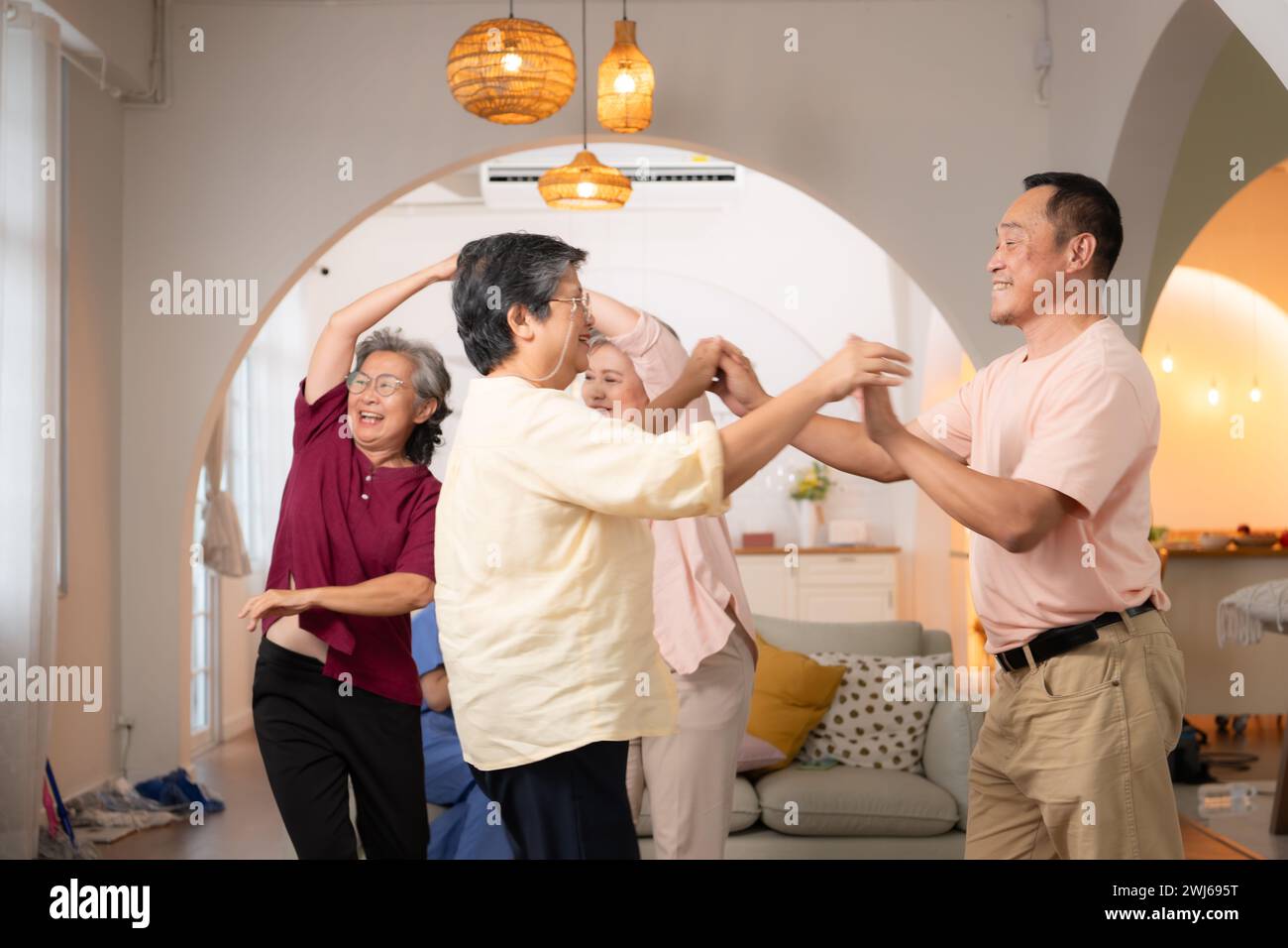 Eine Gruppe älterer asiatischer Menschen tanzen glücklich zusammen im Altersheim Stockfoto