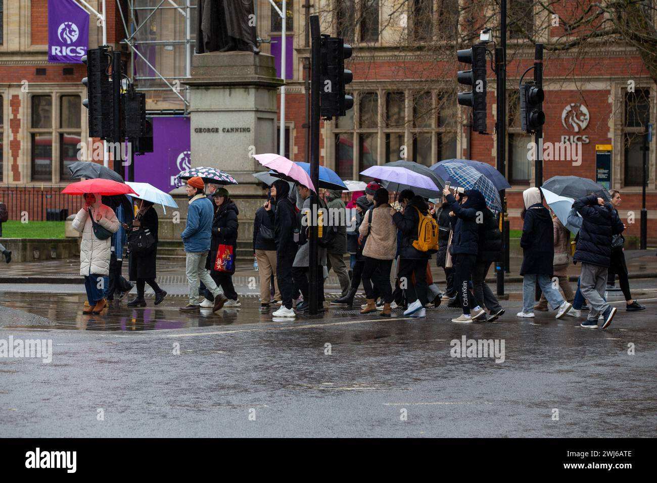 London, UK, 13. Februar 2024 Touristenwarteschlange im Regen mit Regenschirmen, um Fotos von der ikonischen Red Phone Box in London zu machen und die Sehenswürdigkeiten in London trotz Regen zu genießen Credit: Richard Lincoln/Alamy Live News Stockfoto
