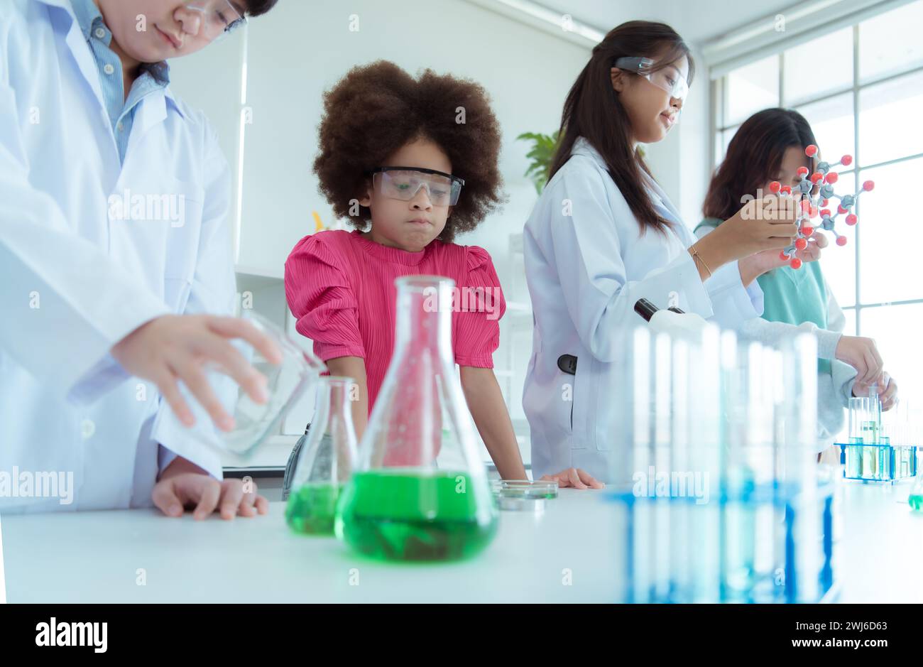 Im Wissenschaftsunterricht experimentierte ein asiatischer Kinderwissenschaftler mit wissenschaftlichen Formeln mit Chemikalien Stockfoto