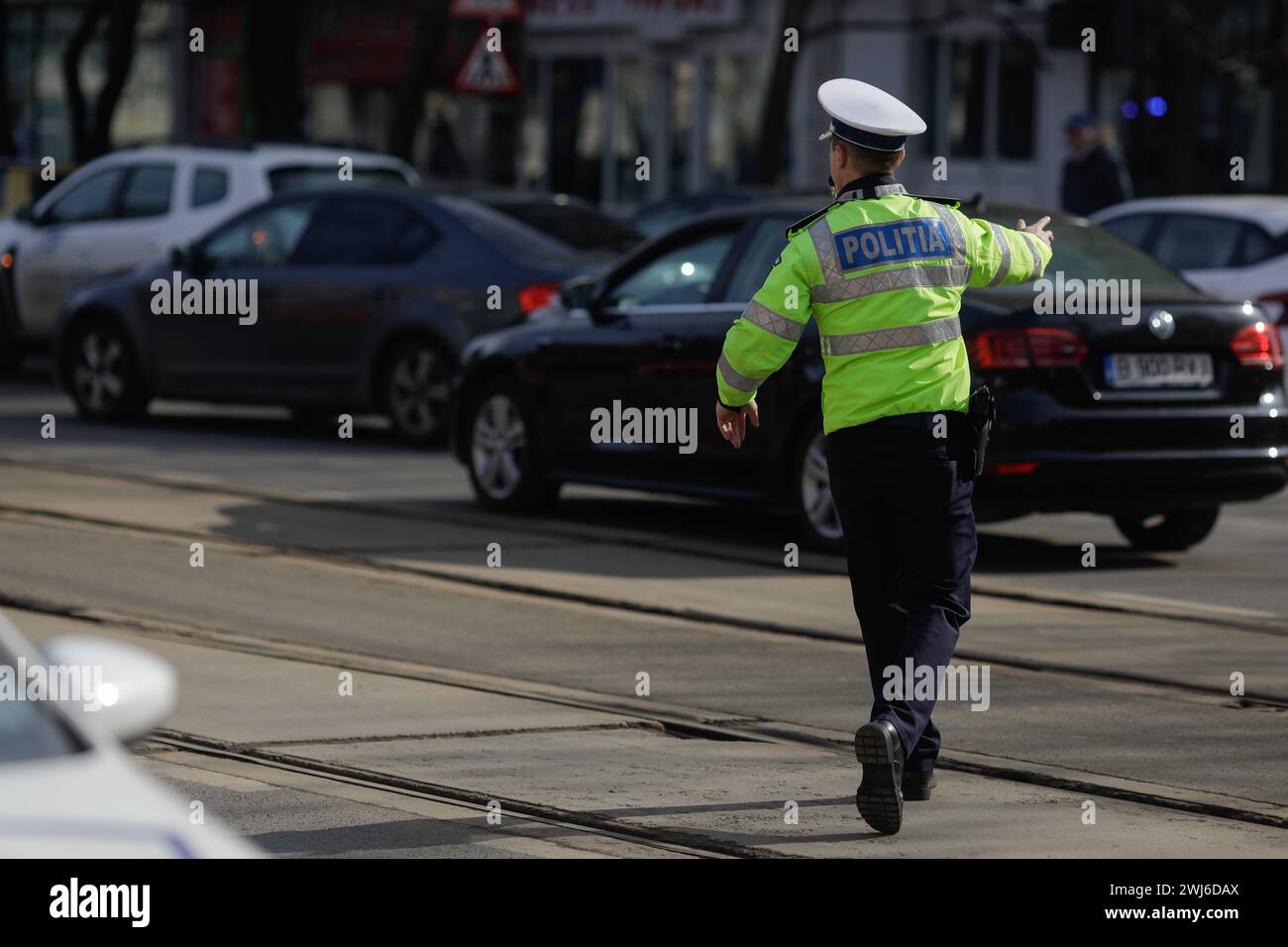 Bukarest, Rumänien - 13. Februar 2024: Rumänischer Straßenpolizisten verwaltet den Verkehr auf einer stark befahrenen Straße. Stockfoto