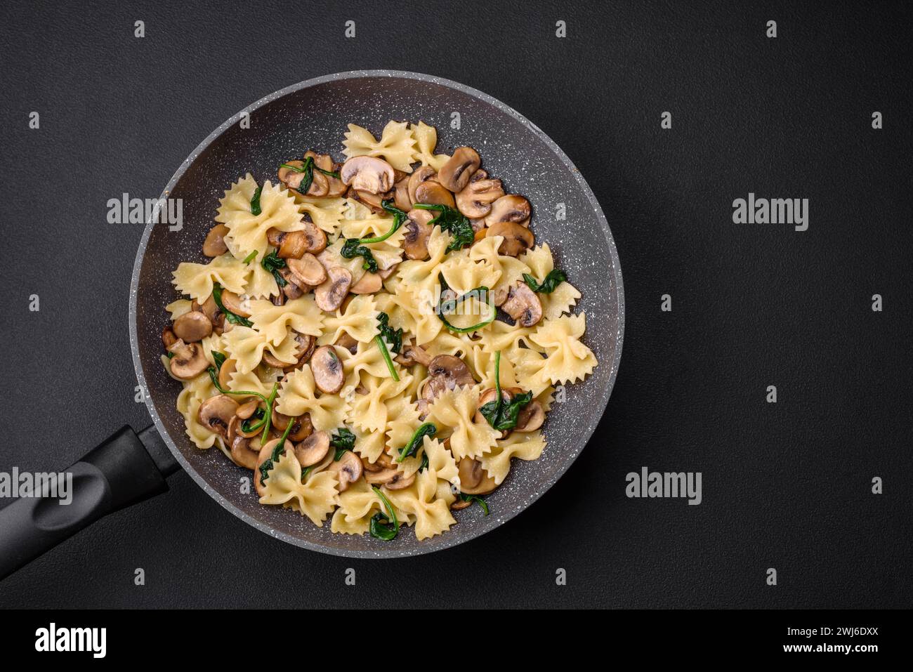 Köstliche Farfalle Pasta mit Pilzen, Käse und Spinat mit Gewürzen Stockfoto