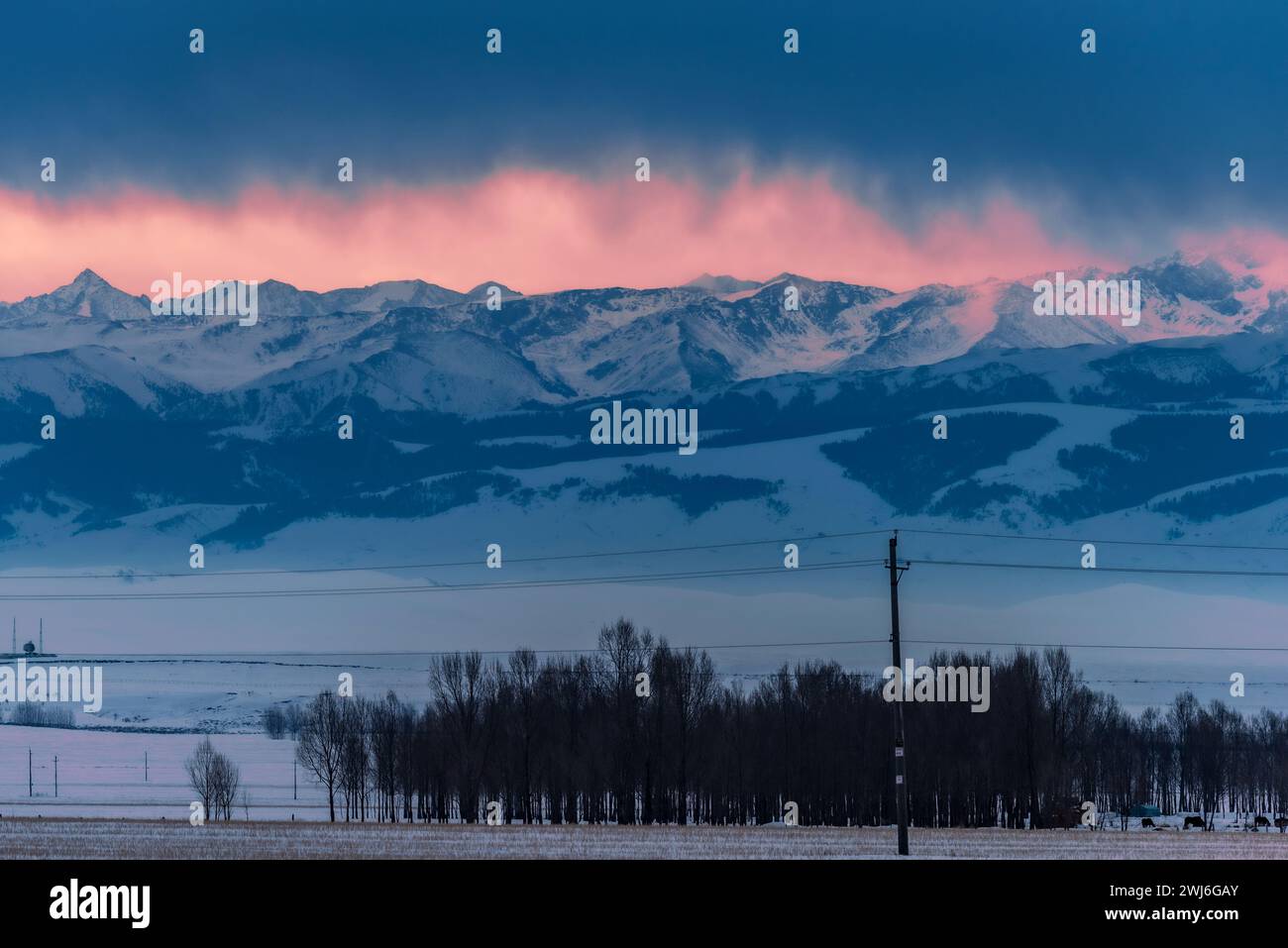 YILI, CHINA - 13. FEBRUAR 2024 - Blick auf die Tianshan-Berge auf der anderen Seite des Plateaus am Vorabend des Sonnenaufgangs in Yili, Provinz Xinjiang, CH Stockfoto