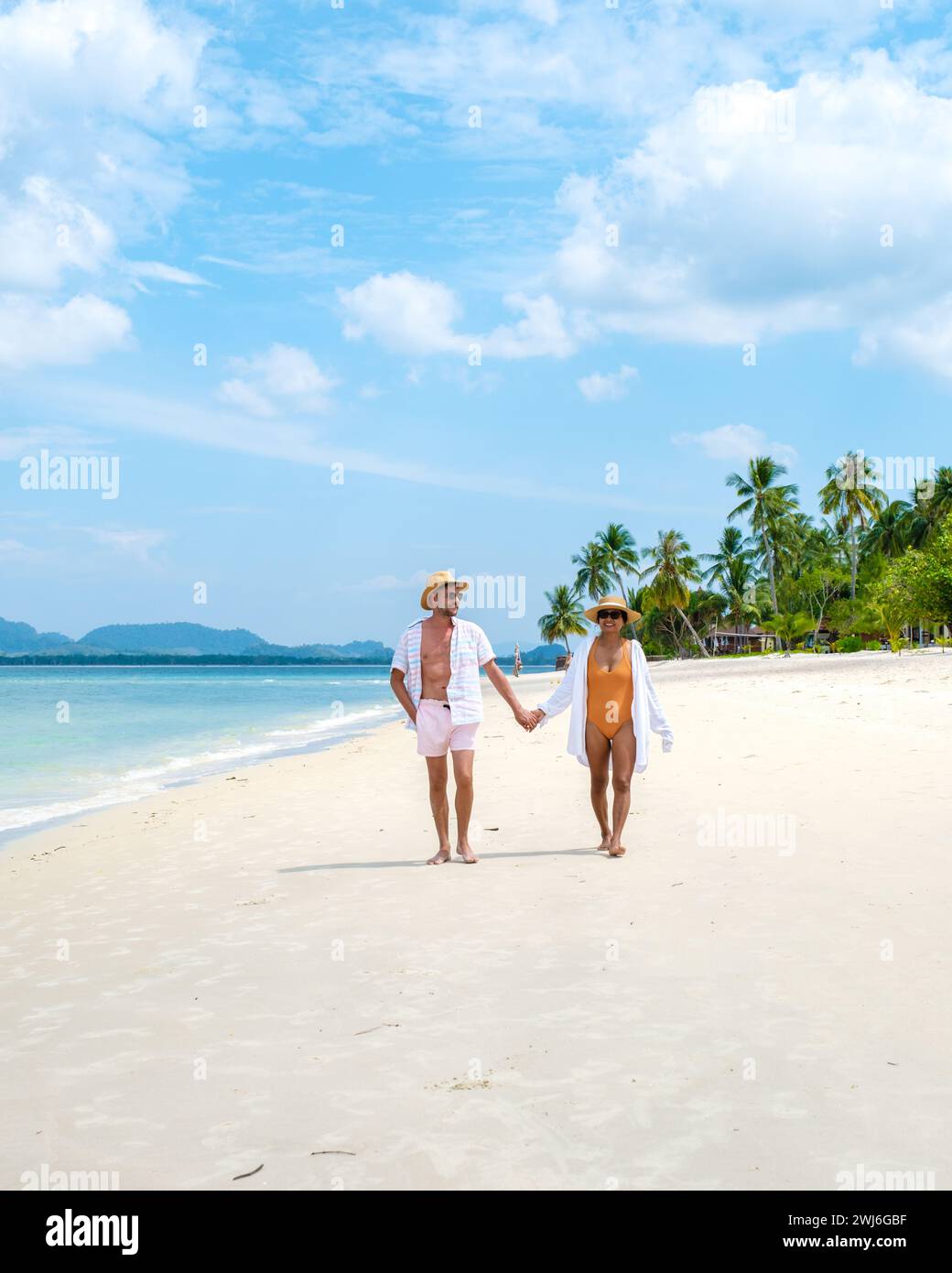 Koh Mook ein junges Paar kaukasischer Männer und thailändische asiatische Frau, die am Strand in Thailand spazieren gehen Stockfoto