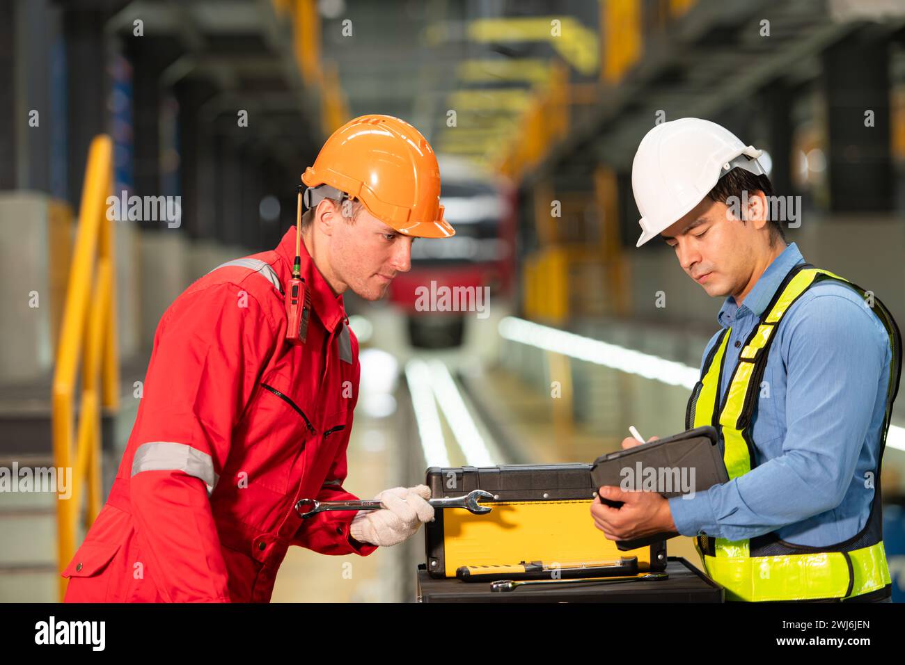 Elektrozugingenieur und Techniker mit Reparaturwerkzeugen der Elektrozugindustrie im Zug befindet sich ein Elektrozug Stockfoto