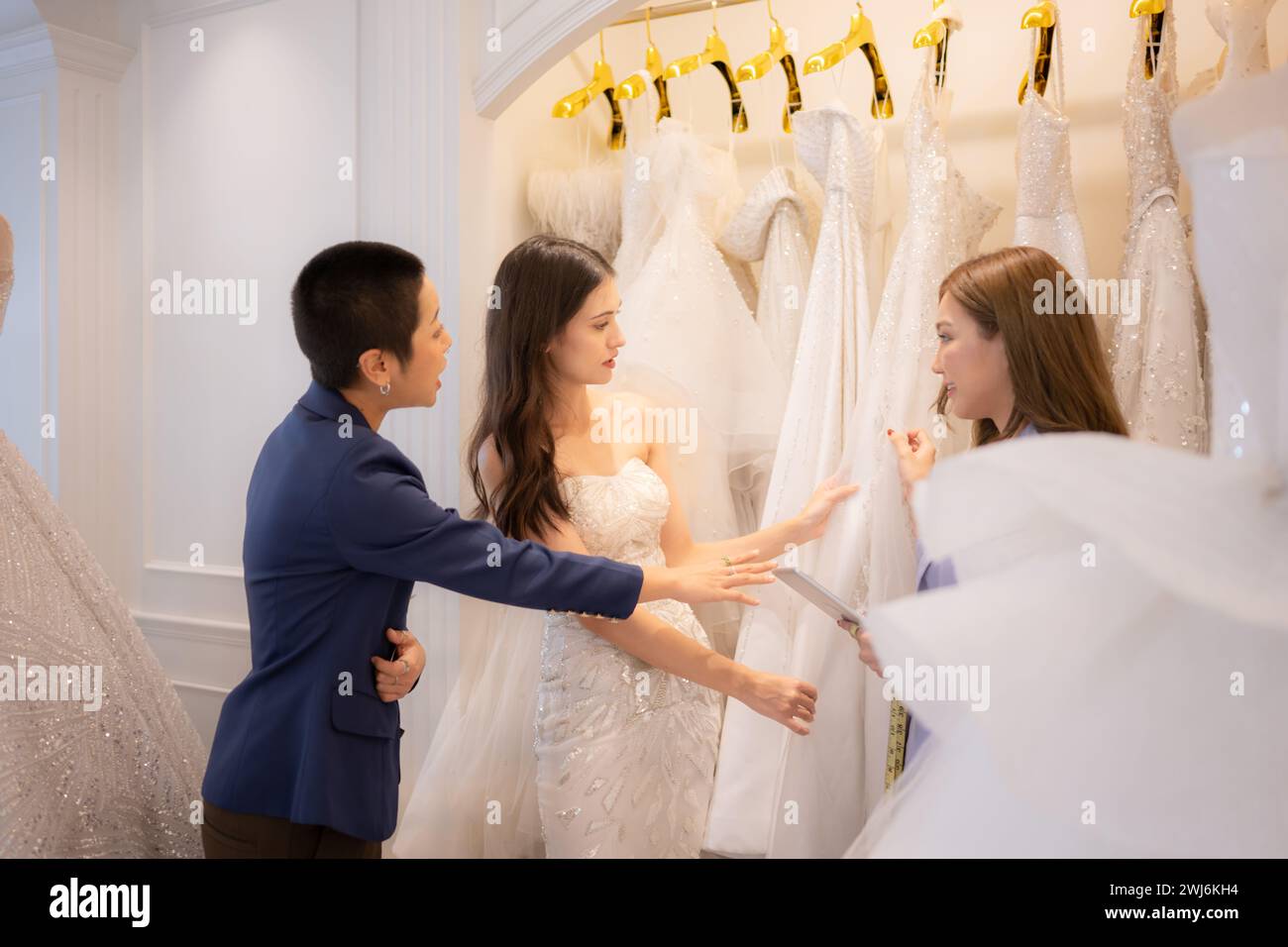 LGBT-Paare entscheiden sich für Hochzeitskleider und Designer beraten sie, wie sie für die Braut geeignet und reizend sind. Stockfoto