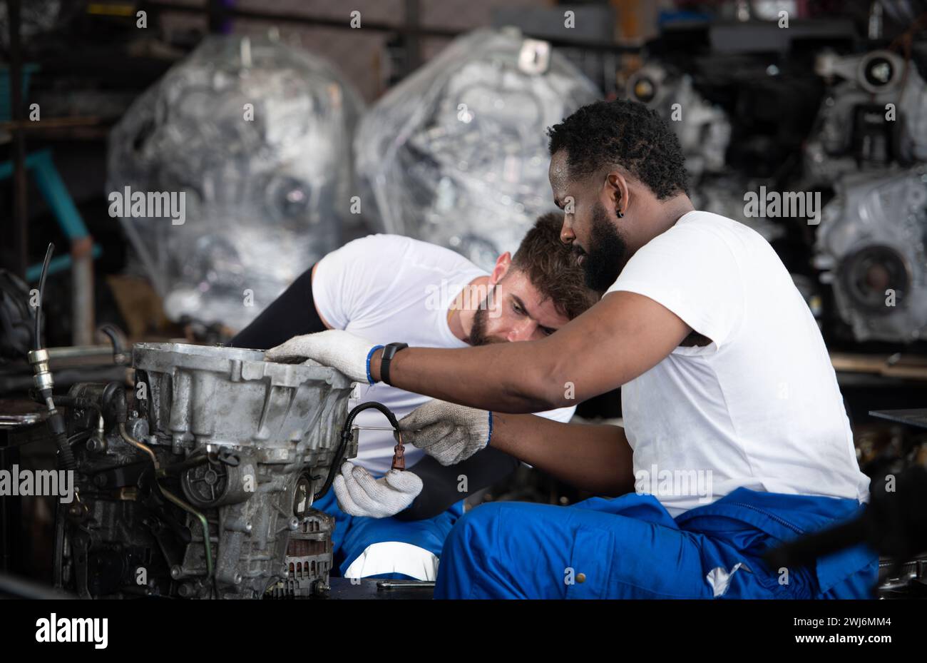 Zwei Männer reparieren den Motor in der Autowerkstatt, selektiver Fokus. Stockfoto
