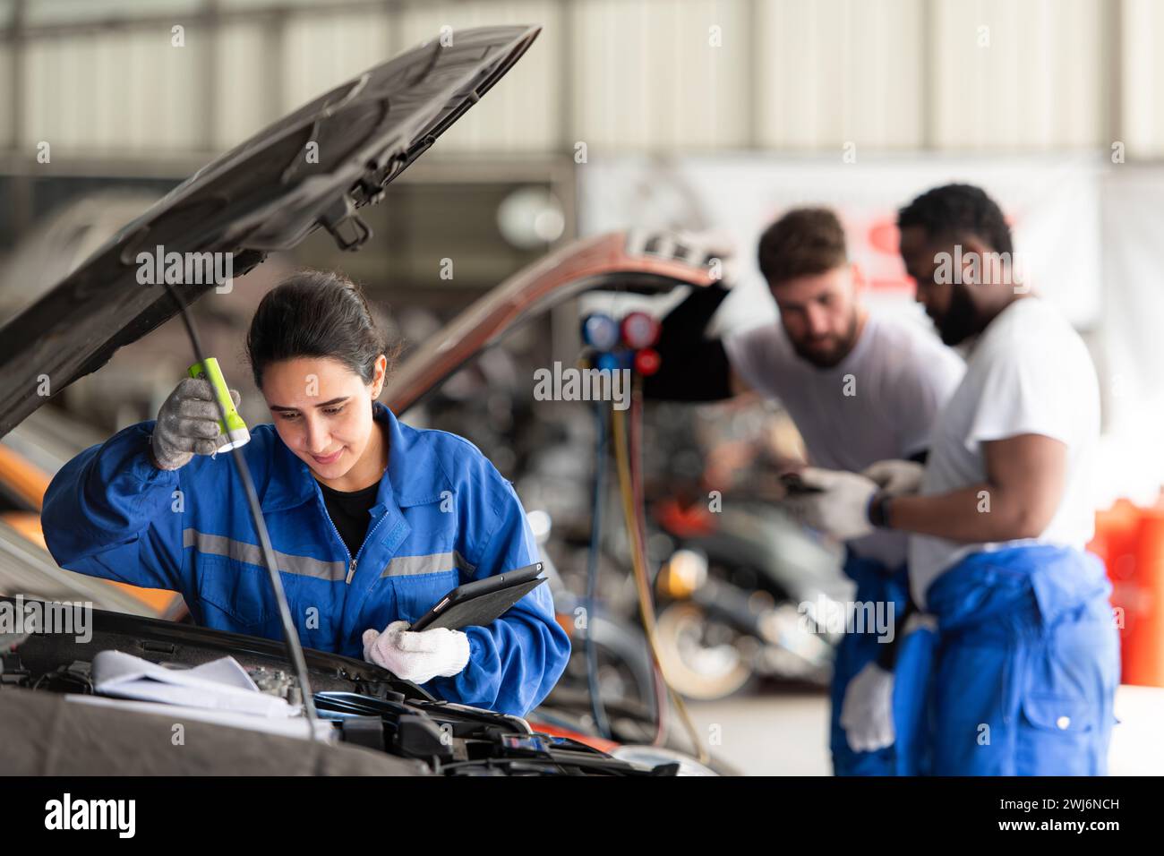 Der Automechaniker arbeitet in einer Autowerkstatt, überprüft die Funktion der Klimaanlage und des Kältemittels des Fahrzeugs und konzentriert sich auf Wom Stockfoto