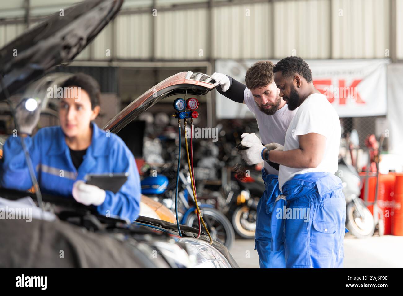 Der Automechaniker arbeitet in einer Autowerkstatt, überprüft die Funktion der Klimaanlage und des Kältemittels des Fahrzeugs und konzentriert sich auf Wom Stockfoto