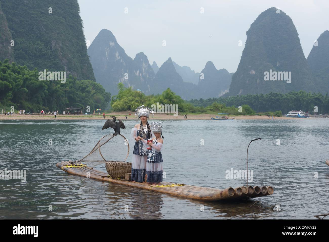 Eine Mutter und Tochter in traditionellen chinesischen Miao-Kostümen machen künstlerische Fotos am Ufer des Li-Flusses Stockfoto