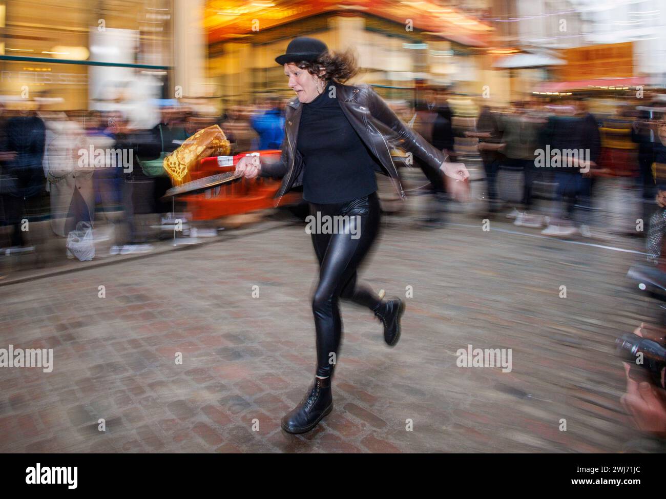 London, Großbritannien. Februar 2024. Jährliches Pfannkuchenrennen auf dem Leadenhall Market. Das Rennen in der City of London findet heute im 15. Jahr statt und wird vom historischen Pub The Lamb aus dem 18. Jahrhundert organisiert. Quelle: Karl Black/Alamy Live News Stockfoto