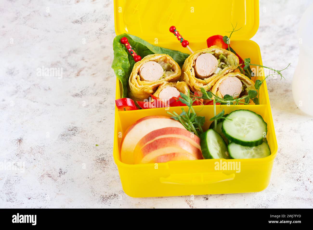 Schulbrotdose mit Wurstbrötchen in Omelette mit Lavash. Lunchbox. Keto-Mittagessen. Stockfoto