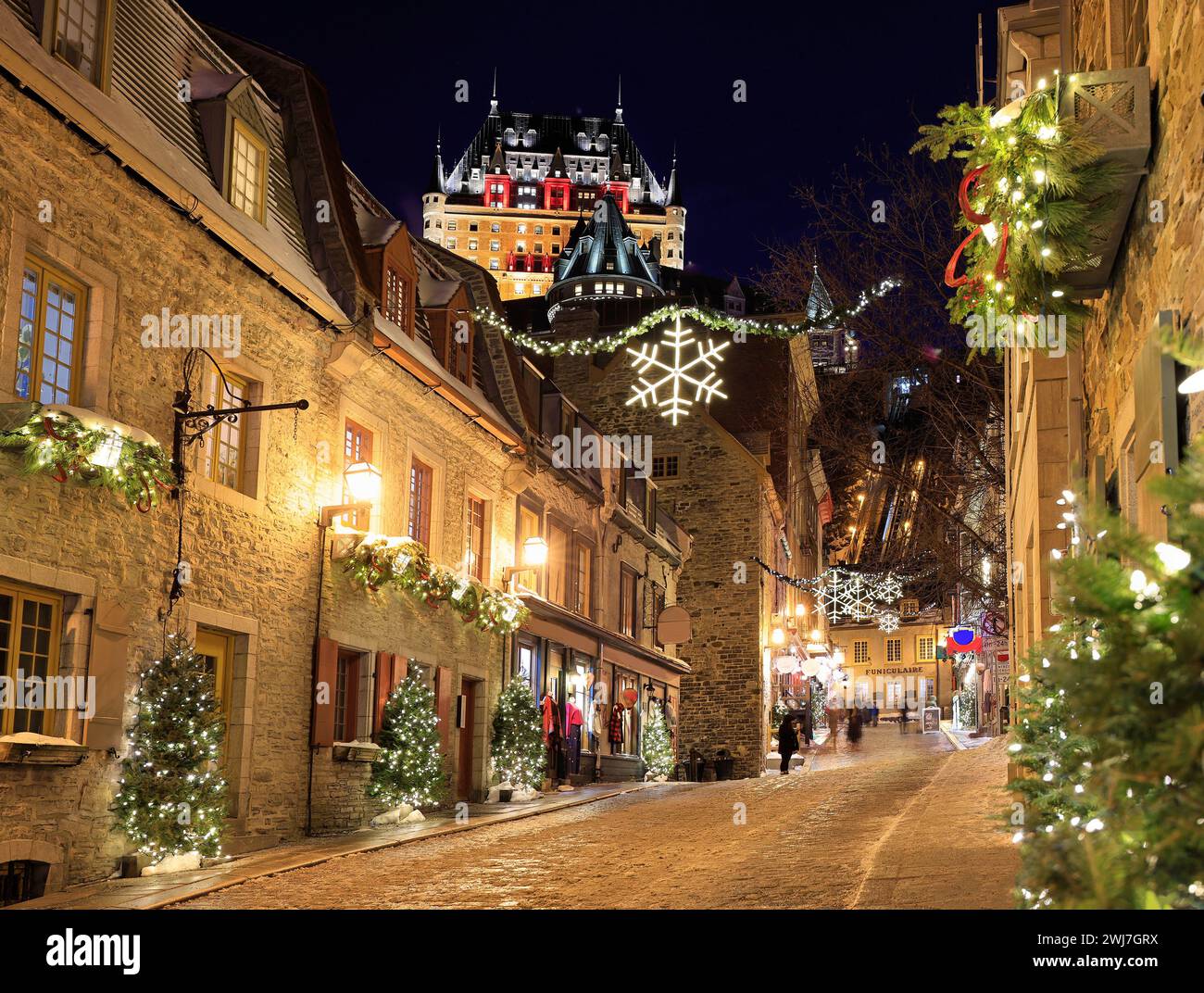 Die Skyline von Quebec City wird im Winter bei Dämmerung beleuchtet. Die Rue Sous-le-Fort ist weihnachtlich dekoriert Stockfoto