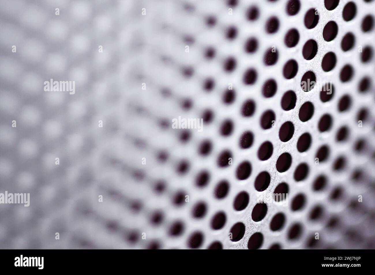 Abstrakte Nahaufnahme des Lautsprechergitters mit metallischer Oberfläche. Geringe Schärfentiefe, fotografiert mit einem Makroobjektiv. Stockfoto