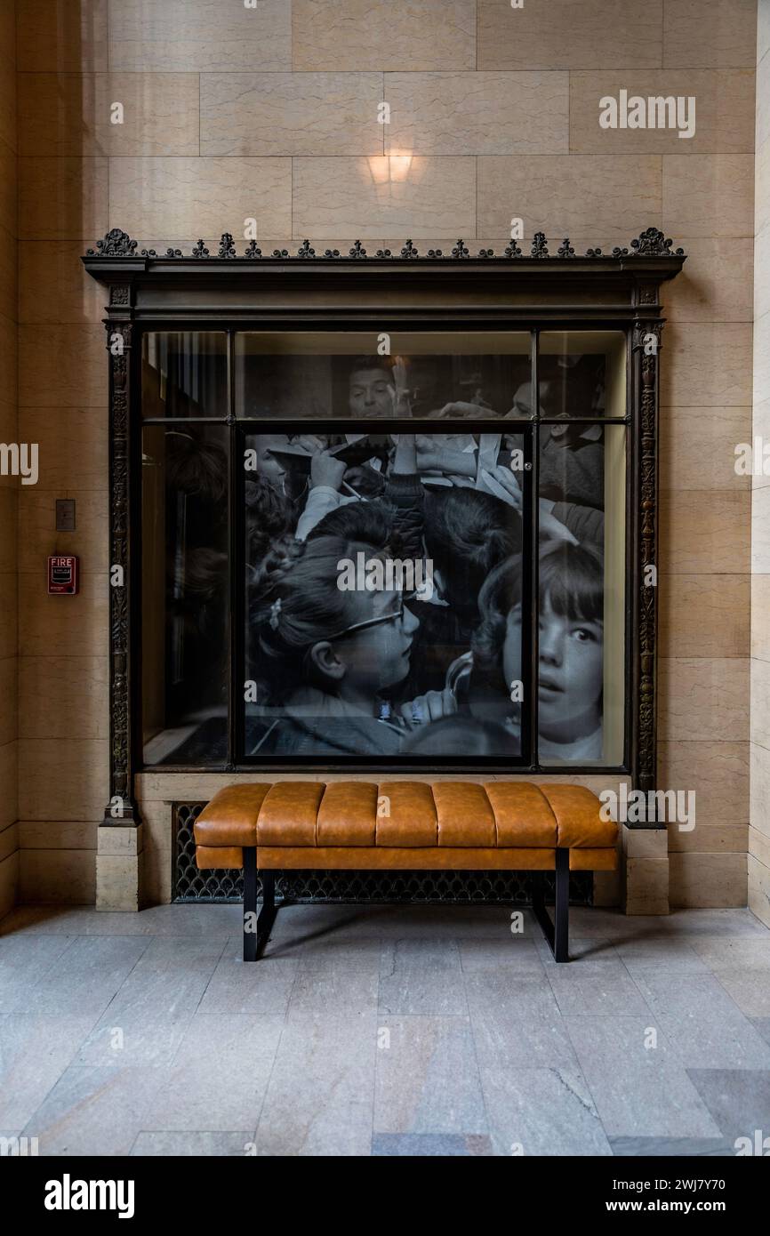 Eine zeitgenössische Kunstinstallation ergänzt eine elegante Bank in einem architektonischen Innenraum Stockfoto