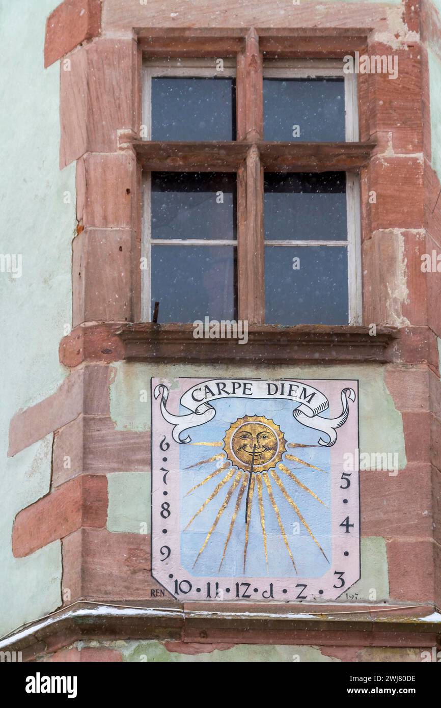 Altes Fenster und eine Sonnenuhr mit der Aufschrift „CARPE DIEM“ auf einer Sandsteinfassade, Elsass, Frankreich Stockfoto
