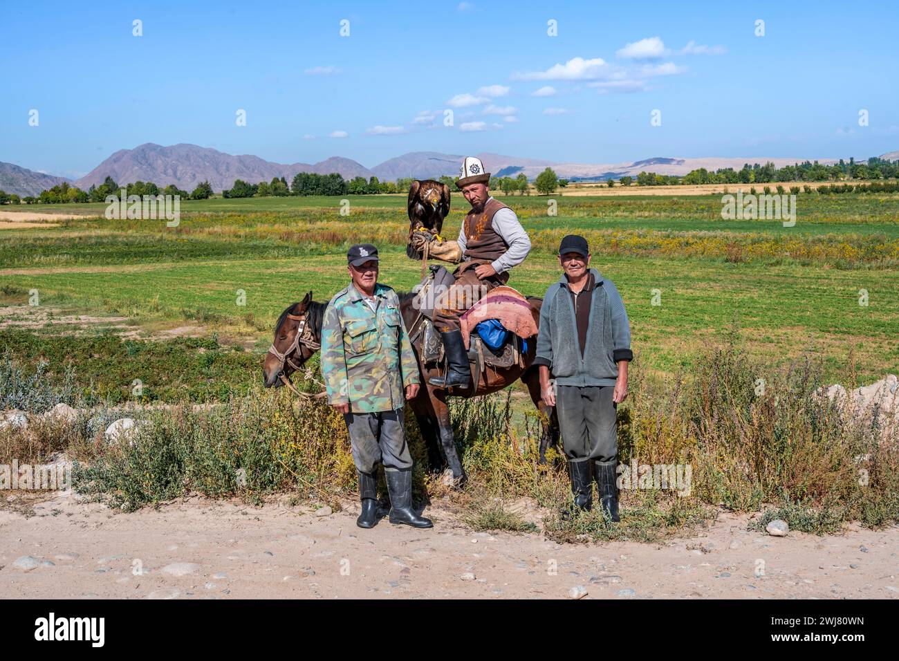 Einheimische Bauern und ein traditioneller kirgisischer Adlerjäger in der Nähe von Kirgisil-Suu, Kirgisistan Stockfoto