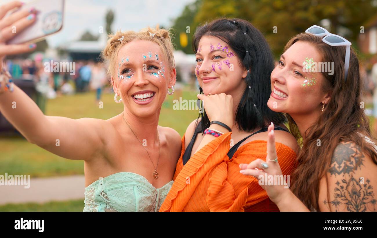 Drei Weibliche Freunde Tragen Glitzer, Die Für Selfie Beim Summer Music Festival Posierten Stockfoto