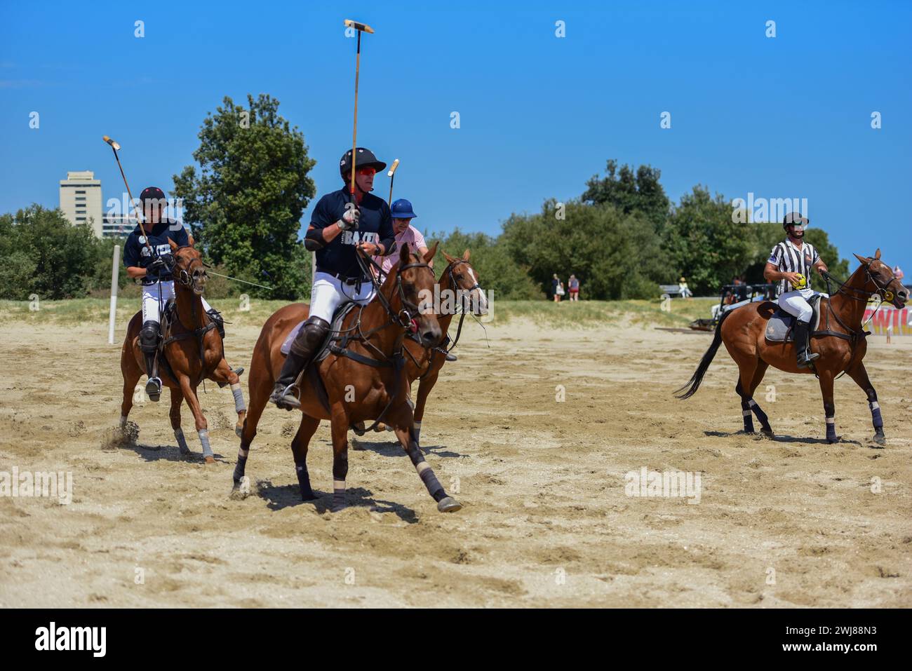 Polo-Spieler von Captain Baxter und Whispering Angel sind in einem Polospiel beim Luxury Escapes Twilight Beach Polo 2024 in Aktion zu sehen. Stockfoto