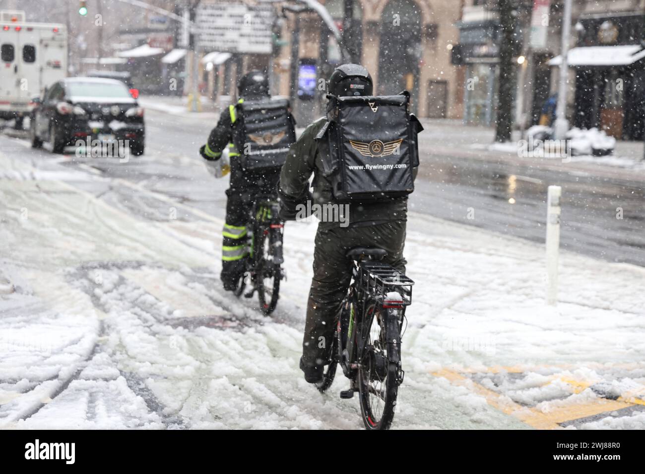 Die Fahrräder der Essenslieferungen fahren die Second Avenue entlang, als ein Wintersturm New York, New York, Dienstag, den 13. Februar 2024, traf. Es ist ein Rekord von 744 Tagen, seit mehr als 2 cm Schnee in New York City gefallen ist, der bis Januar 2022 zurückreicht. (Foto: Gordon Donovan) Stockfoto