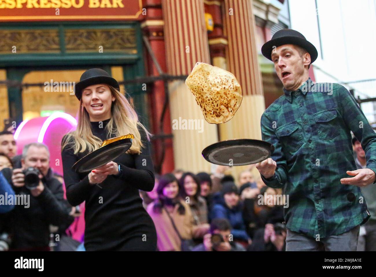 London, Großbritannien. Februar 2024. Die Teilnehmer nehmen an dem jährlichen Fastenpfannkuchenrennen auf dem Leadenhall Market im Zentrum von London Teil. Die Teams werden im 18. Jahrhundert im Pub C The Lamb Tavern C, dem jährlichen traditionellen Event, veranstaltet. Während einer 20 m langen Staffel auf den viktorianischen überdachten Märkten mit Kopfsteinpflaster um Ruhm kämpfen. Quelle: SOPA Images Limited/Alamy Live News Stockfoto