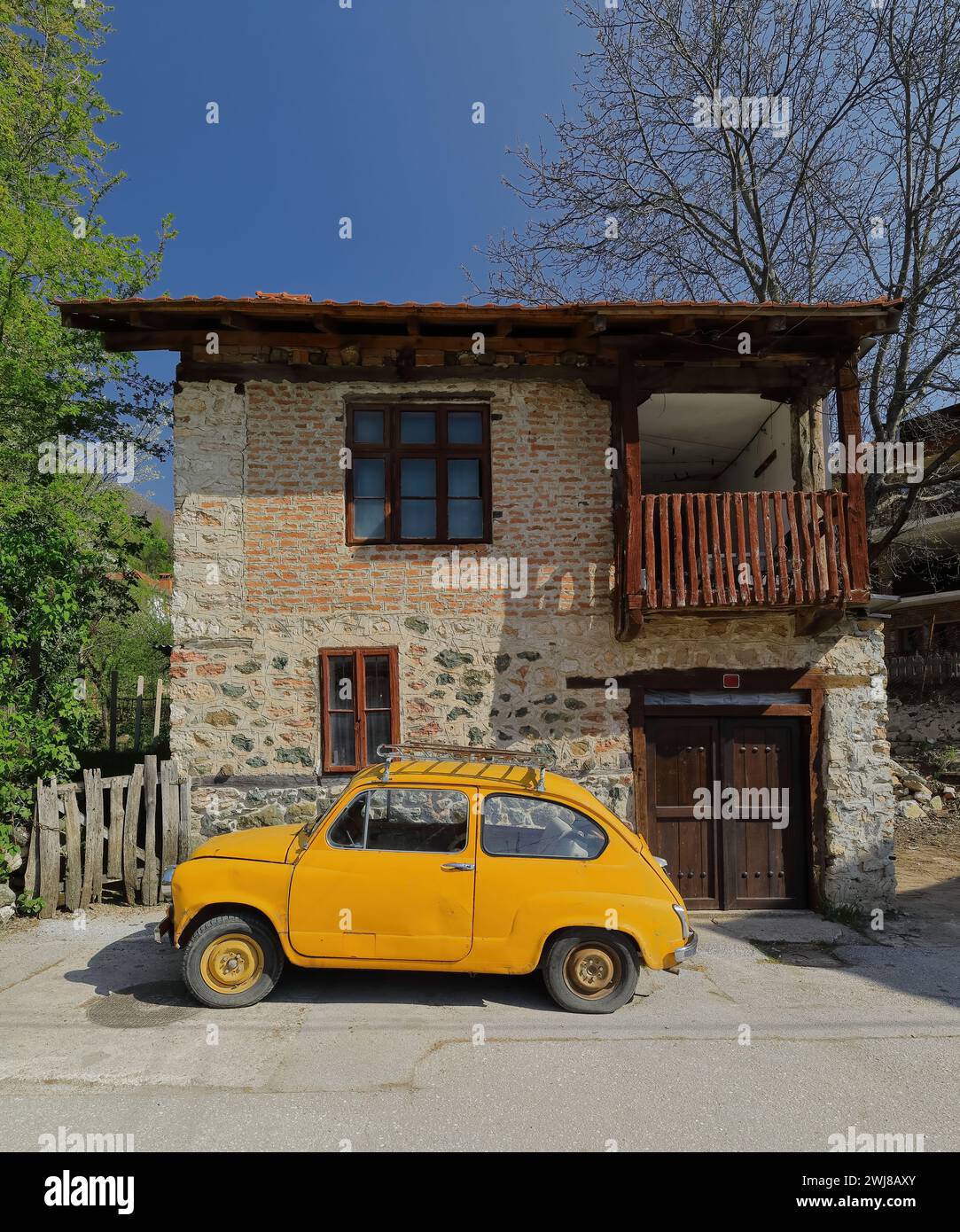 338 klassisches Zastava Z750 LE von 1980, orange-gelb gefärbtes, sogenanntes Fikjo-Auto, parkt vor einem Volkshaus. Vevchani-Nordmazedonien. Stockfoto