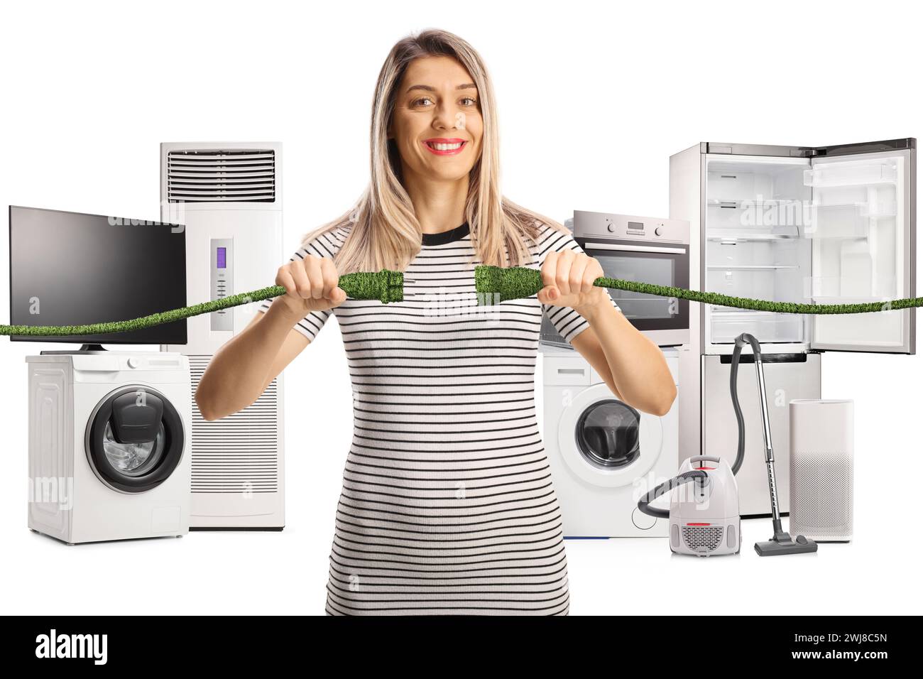 Glückliche junge Frau mit grünen Kabeln vor Elektrogeräten isoliert auf weißem Hintergrund Stockfoto