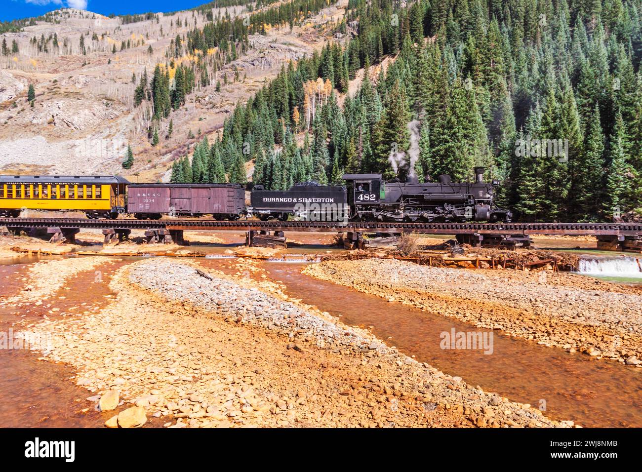 1925 Baldwin Dampflokomotive, 2-8-2 Konfiguration, Typ Mikado, mit antiken, klassischen Triebwagen, an der Animas River Eisenbahnbrücke in Silverton. Stockfoto