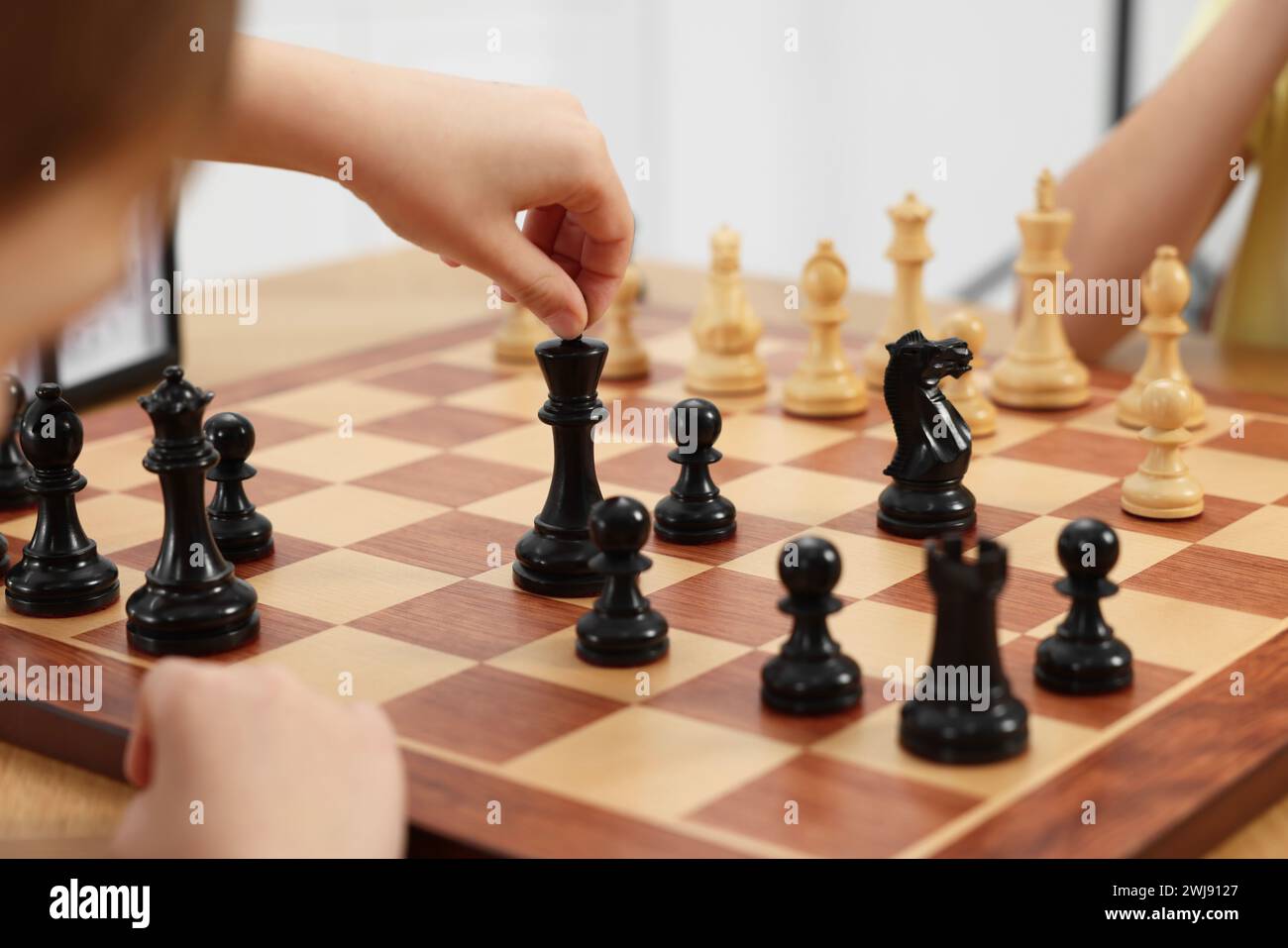 Niedliche Kinder, die Schach spielen, drinnen, Nahaufnahme Stockfoto
