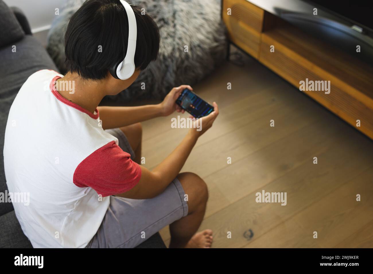 Teenager Asiatische Junge spielt zu Hause gerne auf einem Smartphone Stockfoto