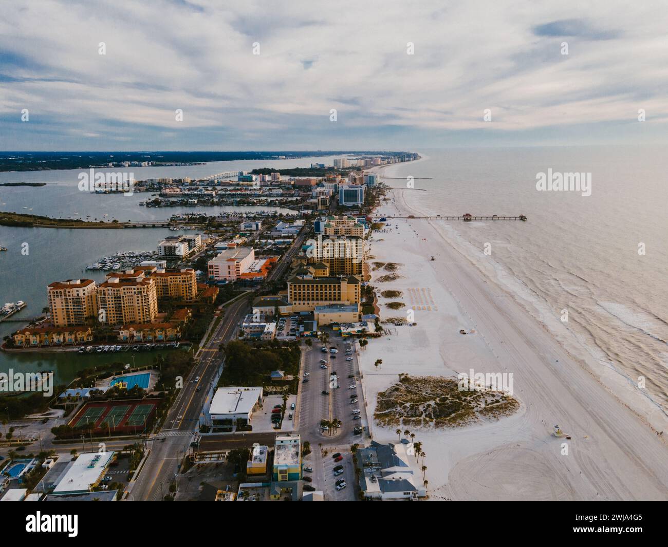 Eine Drohne fängt die weitläufige Küste von Miami mit Gebäuden, Sandstränden und bewölktem Himmel ein und veranschaulicht einen Moment der städtischen und natürlichen Mischung in Florida Stockfoto