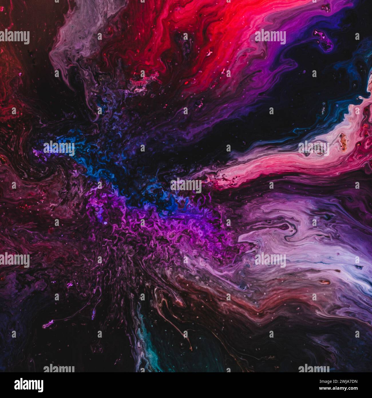 Ein lebendiges, abstraktes Bild mit wirbelnden Rot-, Blau- und Lila-Tönen, das an einen kosmischen Farb- und Lichtstoß erinnert Stockfoto