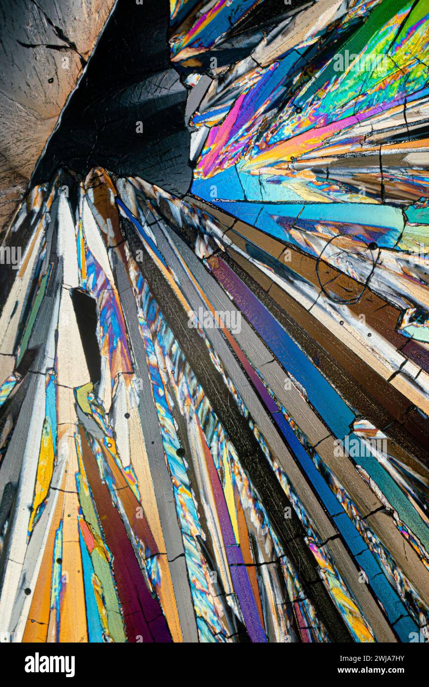 Mikroskopische Darstellung von Erythrit-Zuckerkristallen, die eine strahlende, farbenfrohe geometrische Zusammensetzung mit scharfen Kontrasten und Texturen bilden Stockfoto