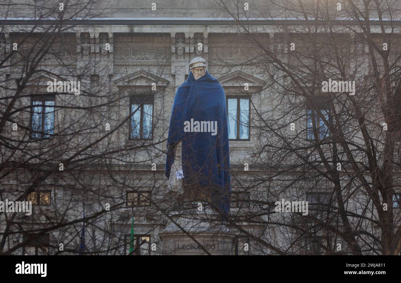 Mailand, Italien. Januar 2024. Foto Stefano Porta/LaPresse14-02-2024 Milano, Italia - Cronaca - Associazione Arca copre con una coperta blu la Statue nel Centro di Milano per sensibilizzare la cittadinanza sul tema dei senza fissa dimora Nella foto: La statua di Leonardo auf der Piazza della Scala 14. Februar 2024 Mailand, Italien - Nachrichten - die Arca Association deckt die Statuen im Zentrum von Mailand mit einer blauen Decke ab, um das Bewusstsein der Bürger für das Thema Obdachlosigkeit zu schärfen Stockfoto