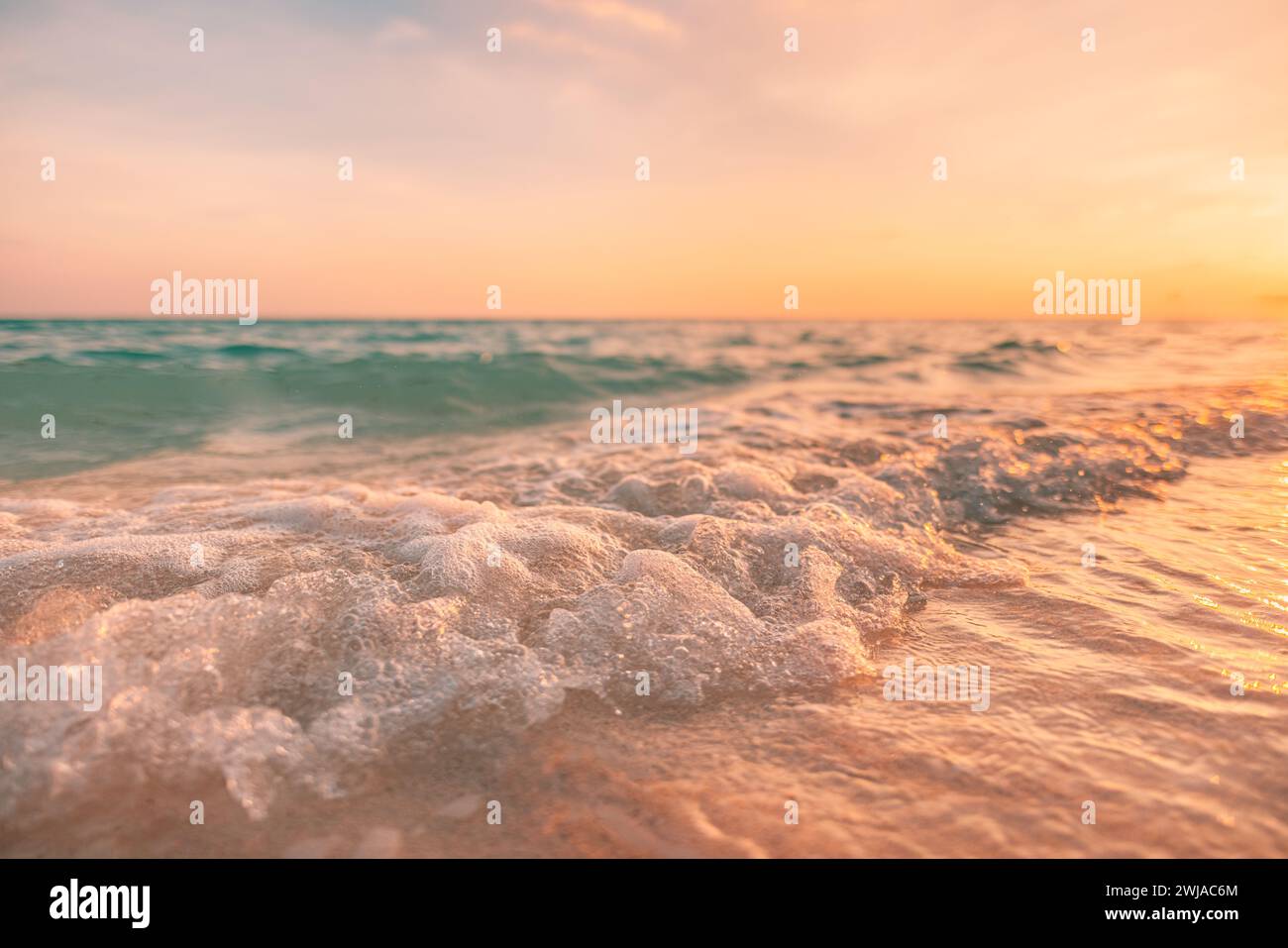 Nahaufnahme Meer Sandstrand. Panoramablick auf die Strandlandschaft. Inspirieren Sie den tropischen Strand am Horizont. Orange und goldener Sonnenuntergang Himmel ruhige ruhige entspannende Sonne Stockfoto
