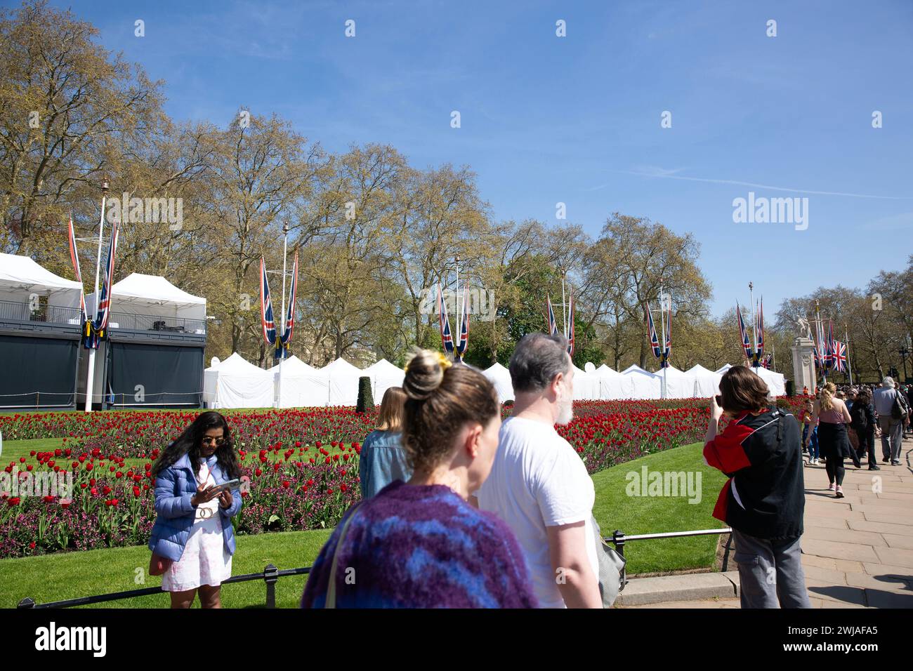 Die Leute gehen an Zelten vorbei, die in der Nähe des Buckingham Palace aufgestellt wurden, während sich London auf die Krönung von König Karl III. Vorbereitet Stockfoto