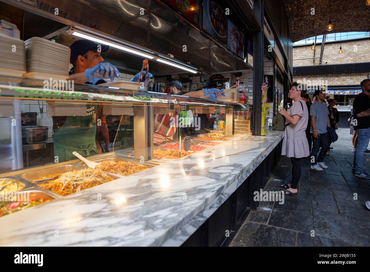 London - 03 06 2022: Eine Dame wählt aus dem Menü eines Halal-Restaurants in Camden Town. Stockfoto