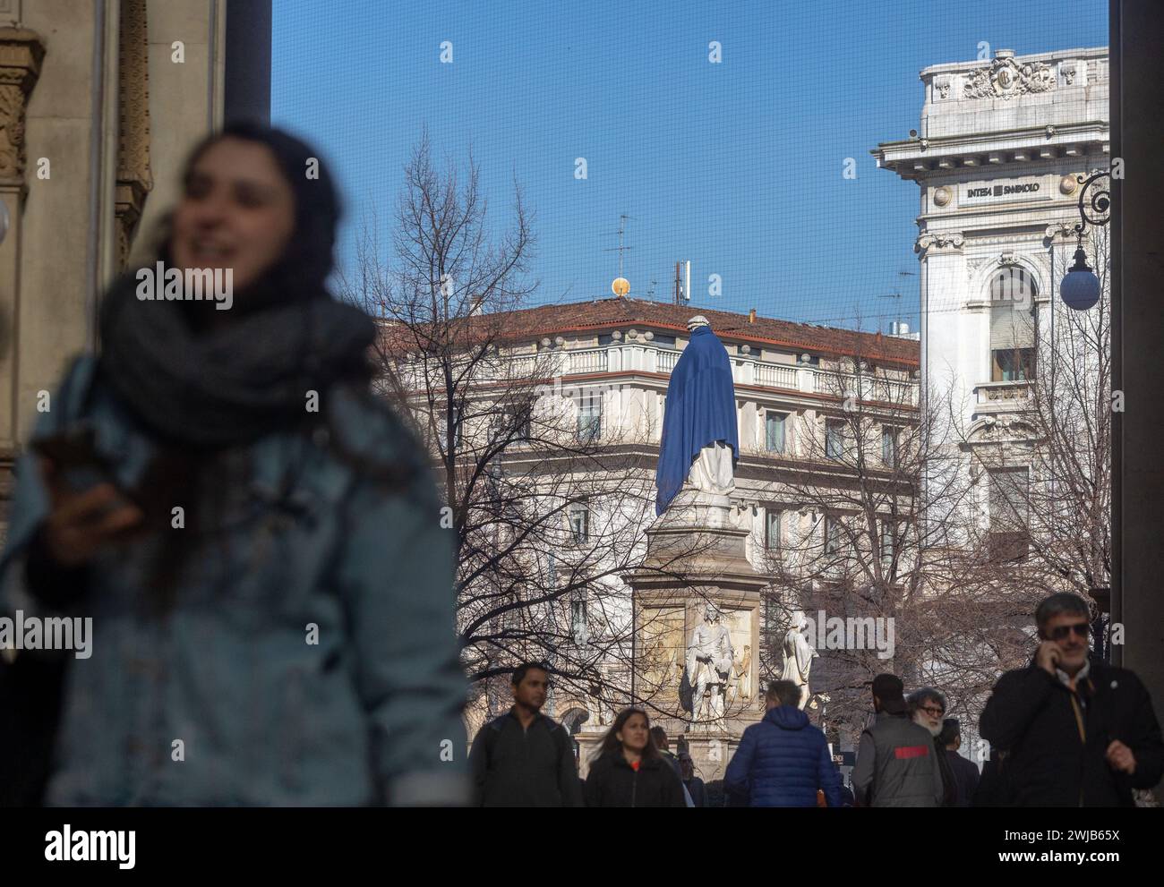 Mailand, Italien. Februar 2024. Foto Stefano Porta/LaPresse14-02-2024 Milano, Italia - Cronaca - Associazione Arca copre con una coperta blu la Statue nel Centro di Milano per sensibilizzare la cittadinanza sul tema dei senza fissa dimora Nella foto: La statua di Leonardo auf der Piazza della Scala 14. Februar 2024 Mailand, Italien - Nachrichten - die Arca Association deckt die Statuen im Zentrum von Mailand mit einer blauen Decke ab, um das Bewusstsein der Bürger für das Thema Obdachlosigkeit zu schärfen Stockfoto