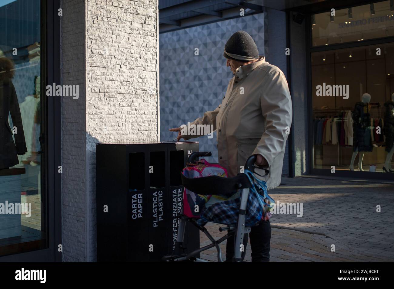 Novara, Italien, 16. Januar 2024: Ein älterer Herr mit einem Rollator macht eine Raucherpause im Einkaufszentrum Stockfoto