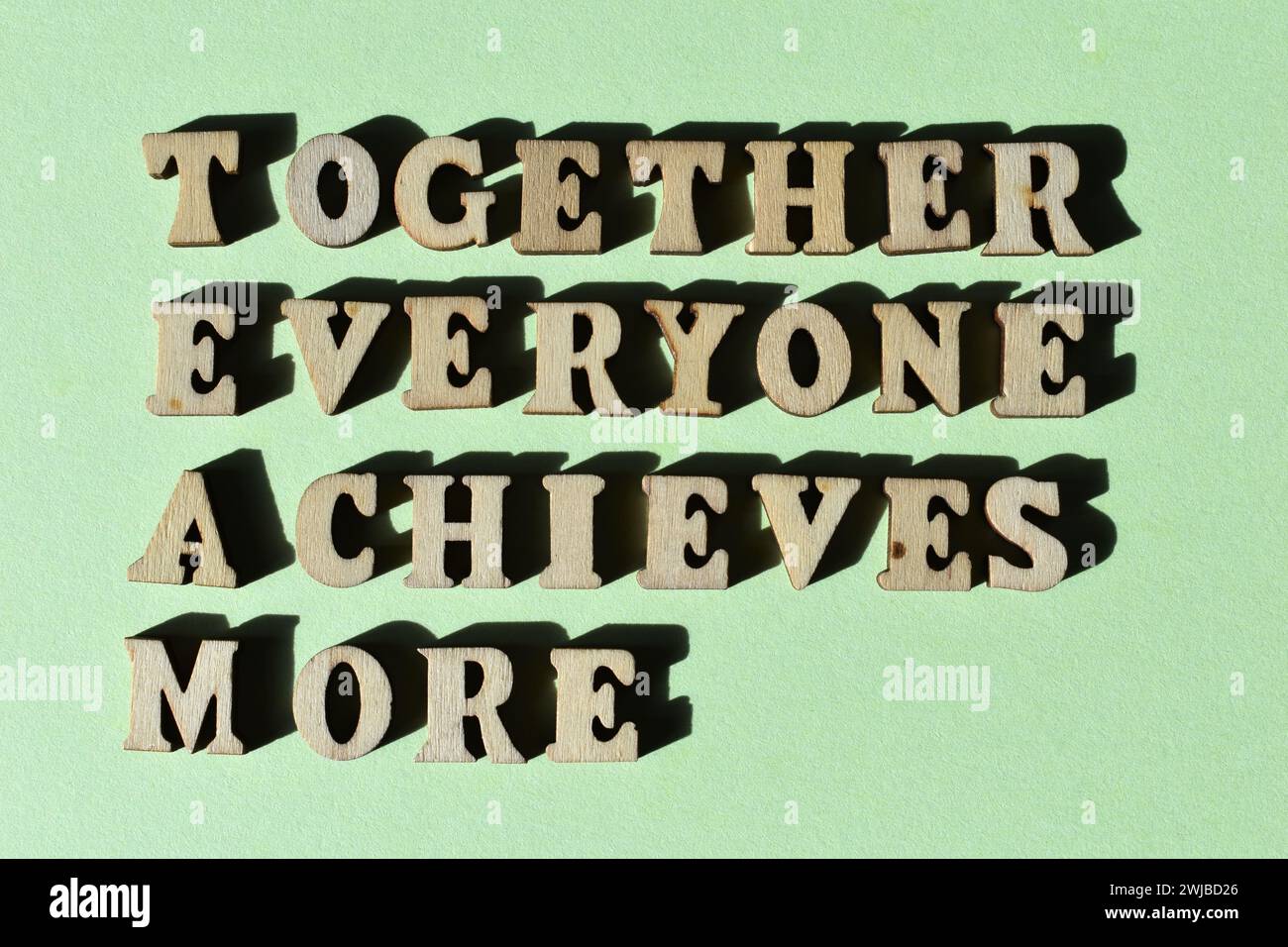 TEAM-Akronym für Together jeder erreicht mehr in Buchstaben aus Holz auf grünem Hintergrund Stockfoto