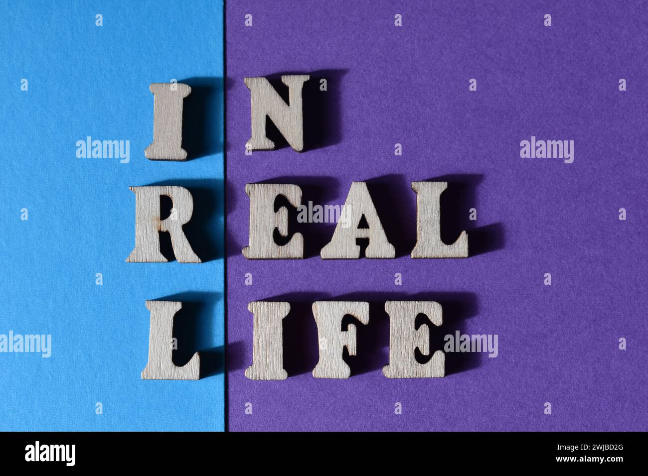 IRL, Akronym für in Real Life, in hölzernen Alphabeten isoliert auf Hintergrund als Banner-Überschrift Stockfoto