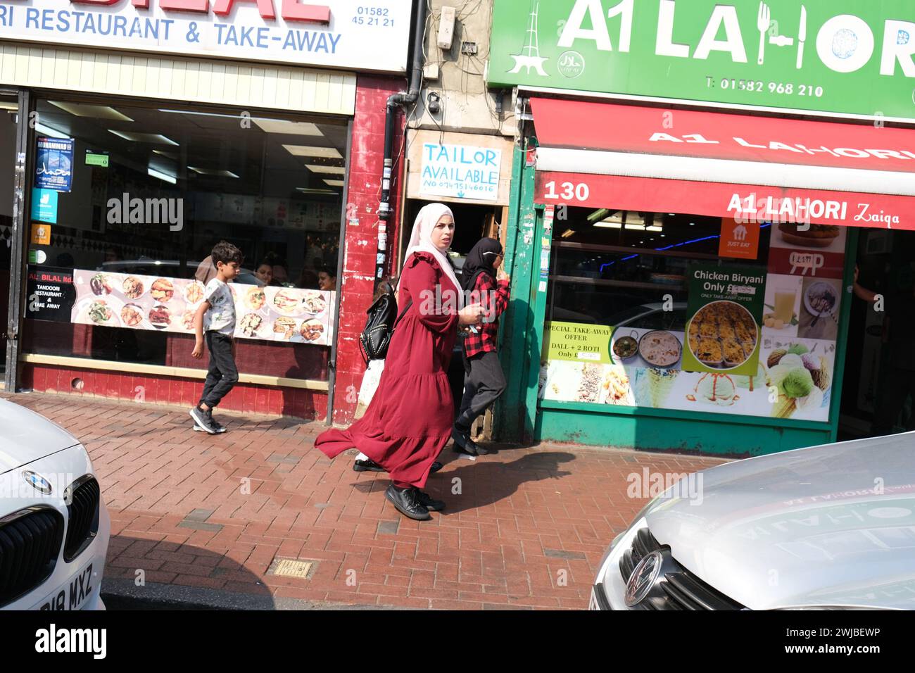 Frau im Hijab spaziert im multikulturellen Bury Park von Luton im Südosten Großbritanniens Stockfoto